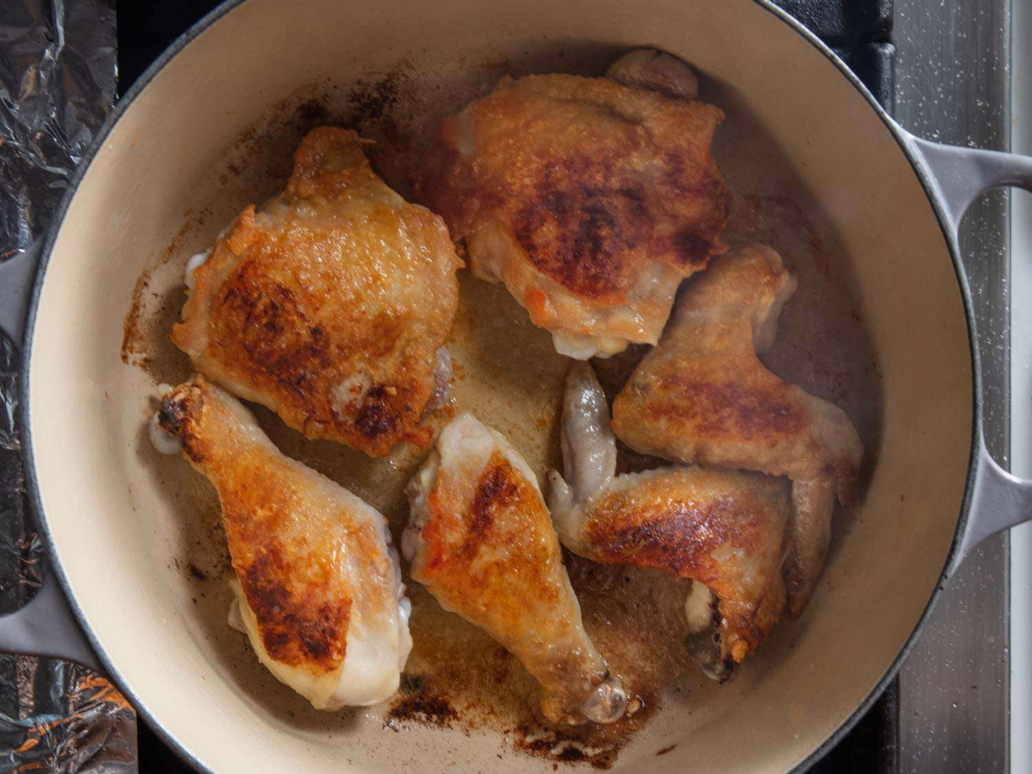 Chicken browning in a Dutch oven for chicken adobo.