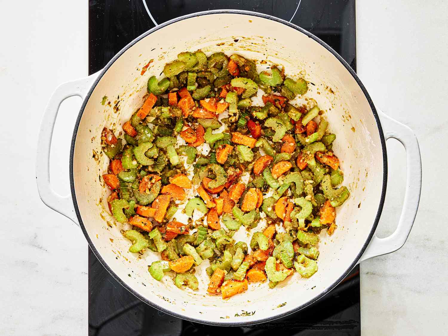 Vegetabled cooking in pot, with flour added and beginning to stick to the bottom of pot