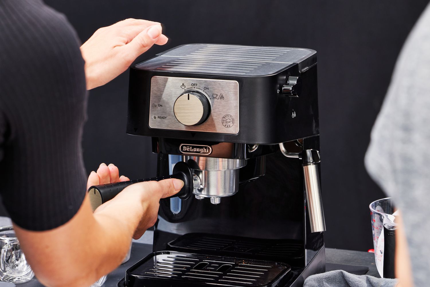 Hands adjusting the portafilter on the De'Longhi Stilosa Espresso Machine