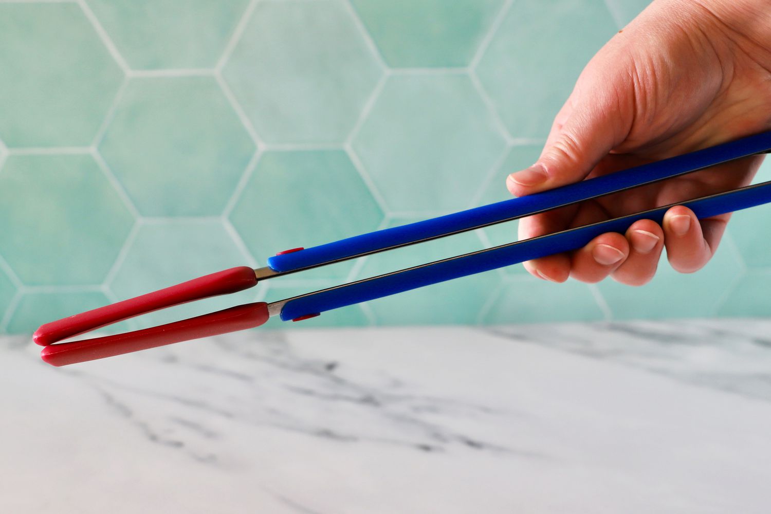 Hand holding the Great Jones Great Tongs