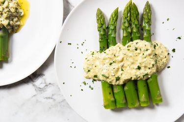 A plate of blanched asparagus dressed with creamy sauce gribiche.