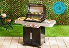 the weber genesis e-325 gas grill on a tile patio with grass behind it