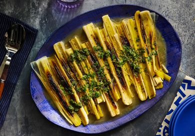 Overhead view of finished leeks plated on a blue platter
