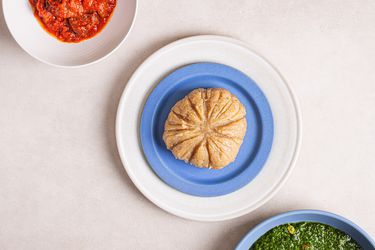 Overhead view of lafun, served with a greens soup and a bowl of obe ata (red pepper sauce).