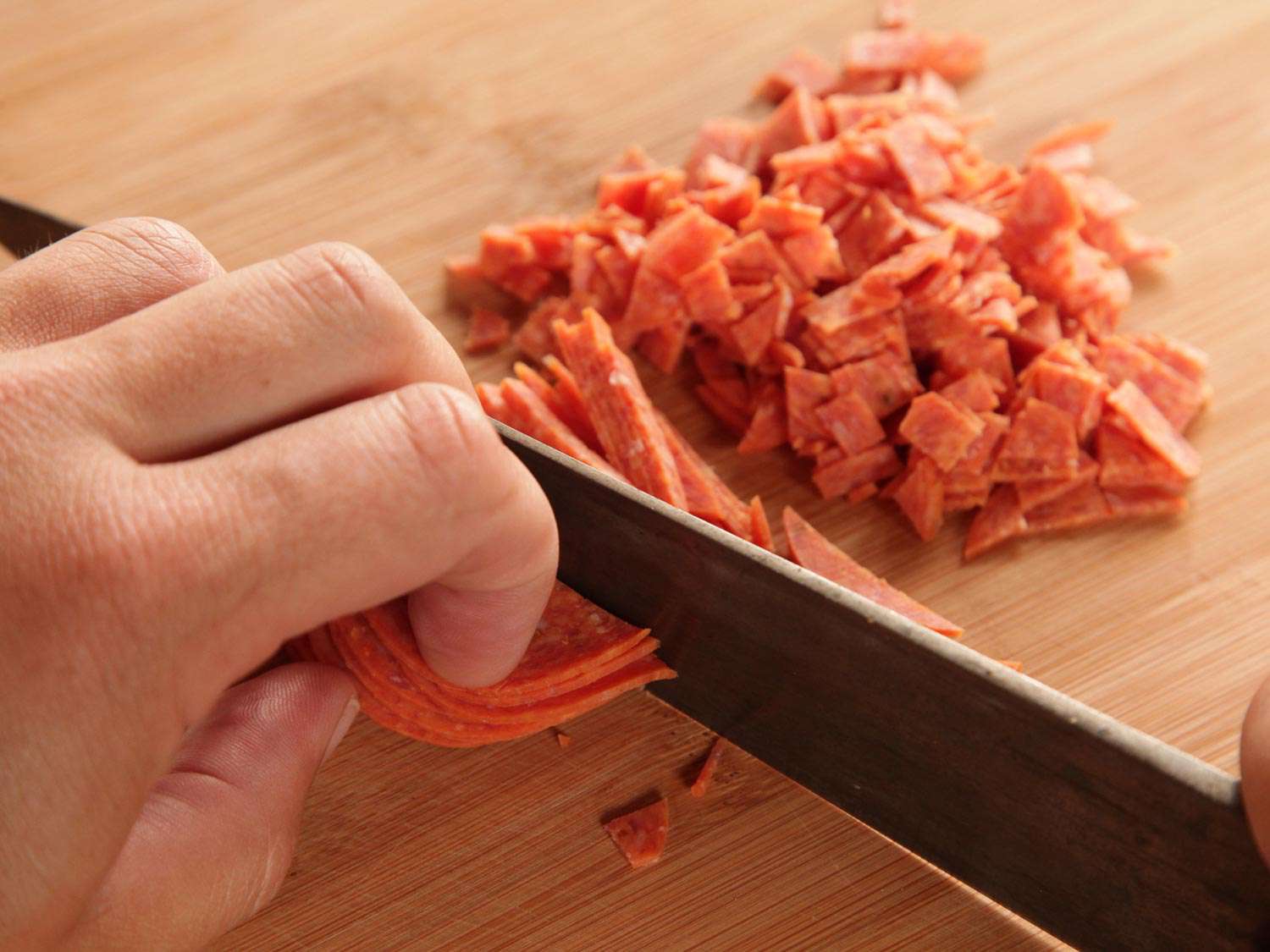 Finely dicing pepperoni for pepperoni garlic knots