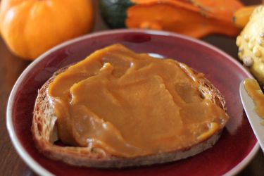 Closeup of a slice of sourdough toast spread with a thick layer of pumpkin butter.