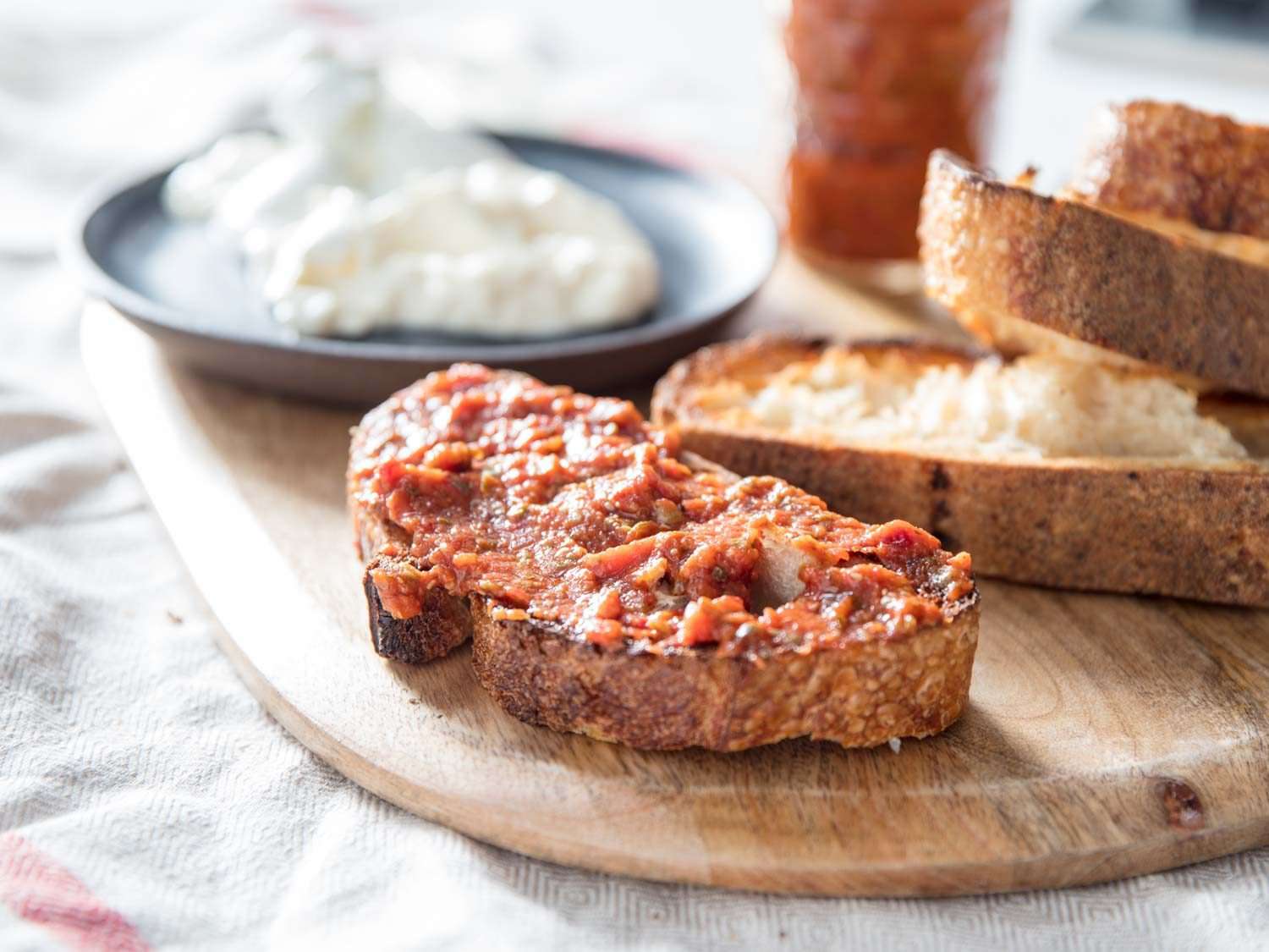 Finished tomato and caper spread on toast with burrata.