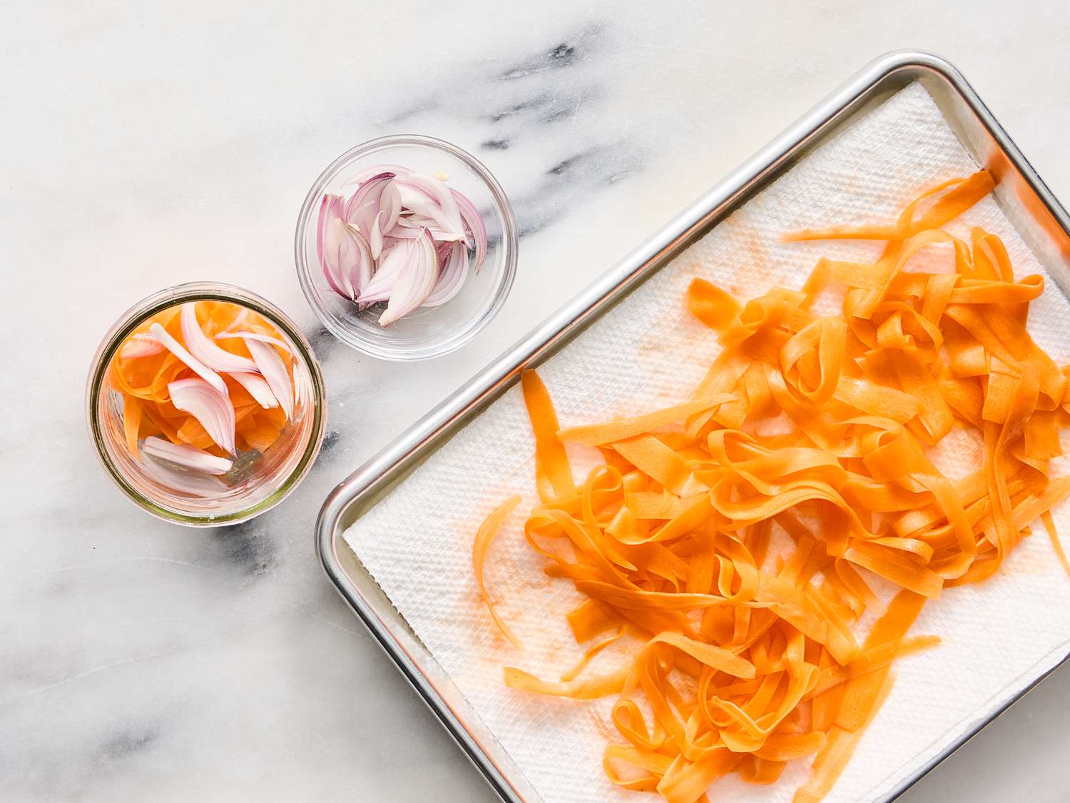 layering carrots and shallots in a jar 