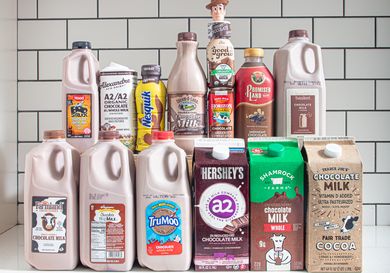 A variety of chocolate milk brands displayed on a counter including cartons and bottles