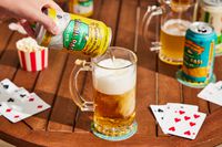 a hand pouring a can of trail pass into a glass