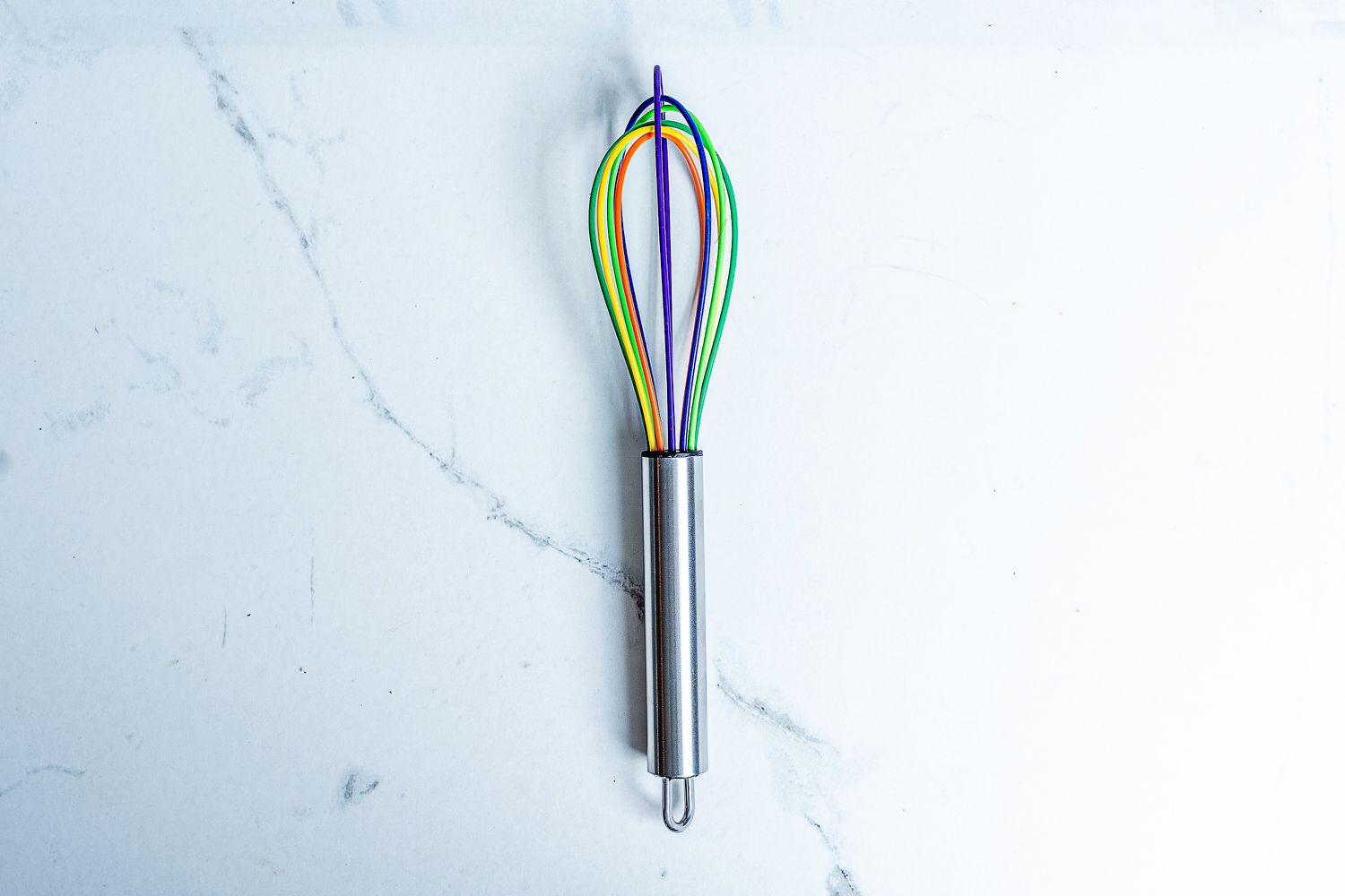 Kuhn Rikon Silicone Rainbow Whisk on a marbled surface