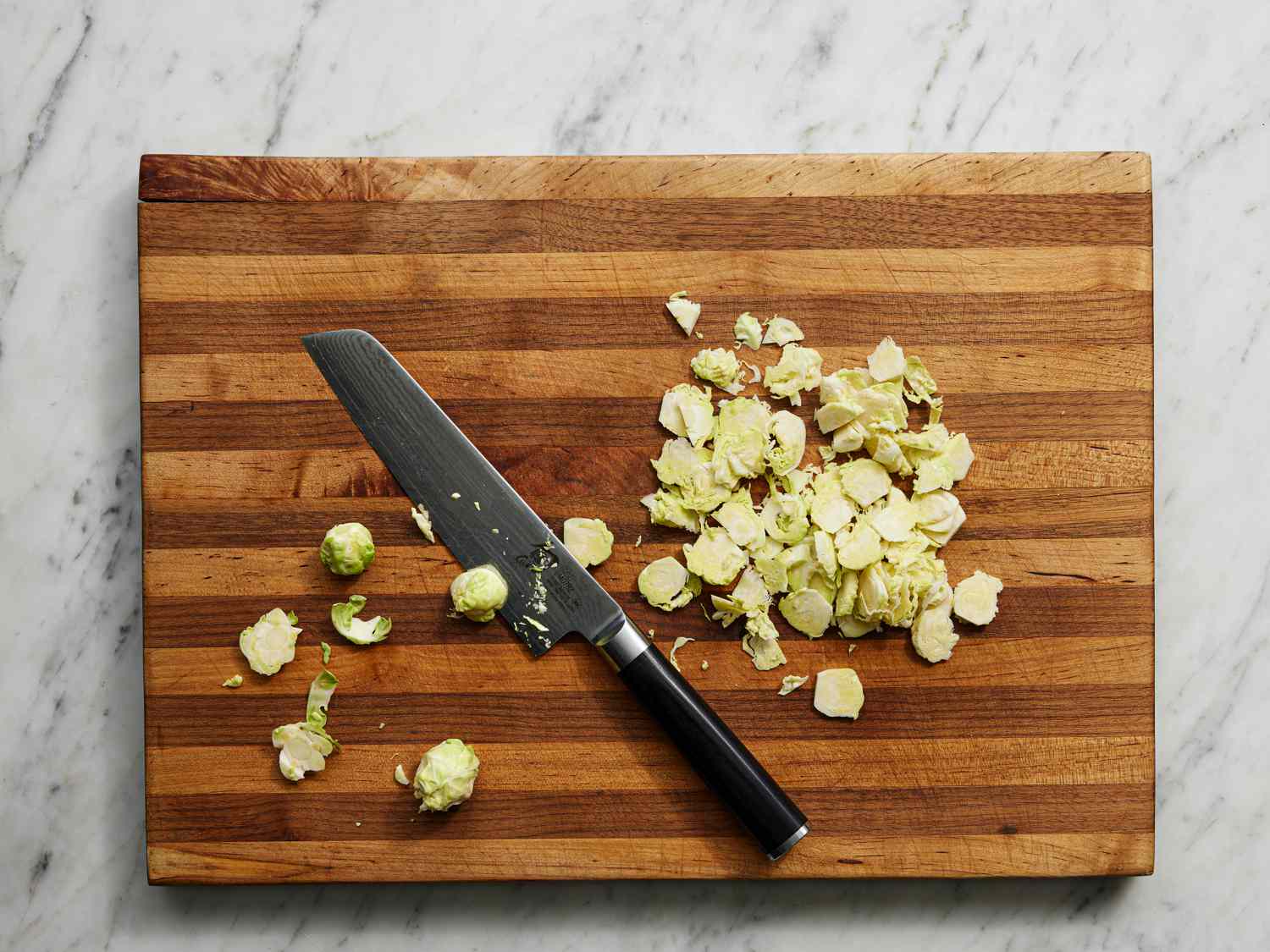 Overhead view of cores of brussels sprouts on a wooden cutting board