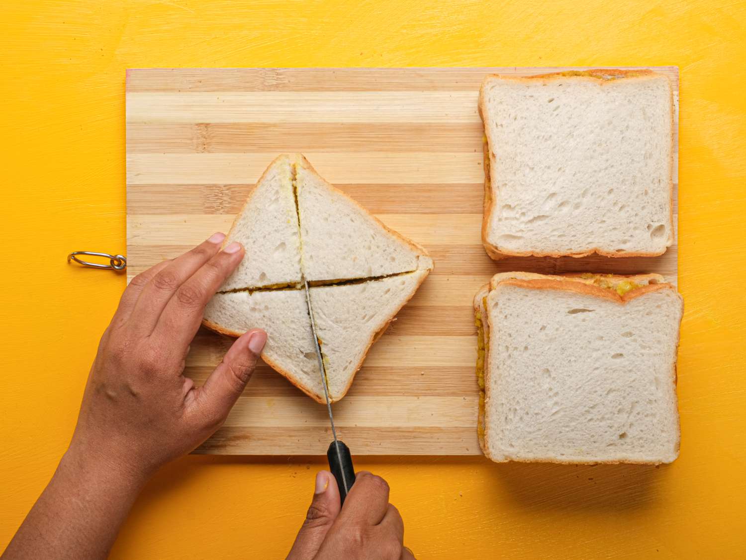 Overhead view of cutting bread pakora into triangles