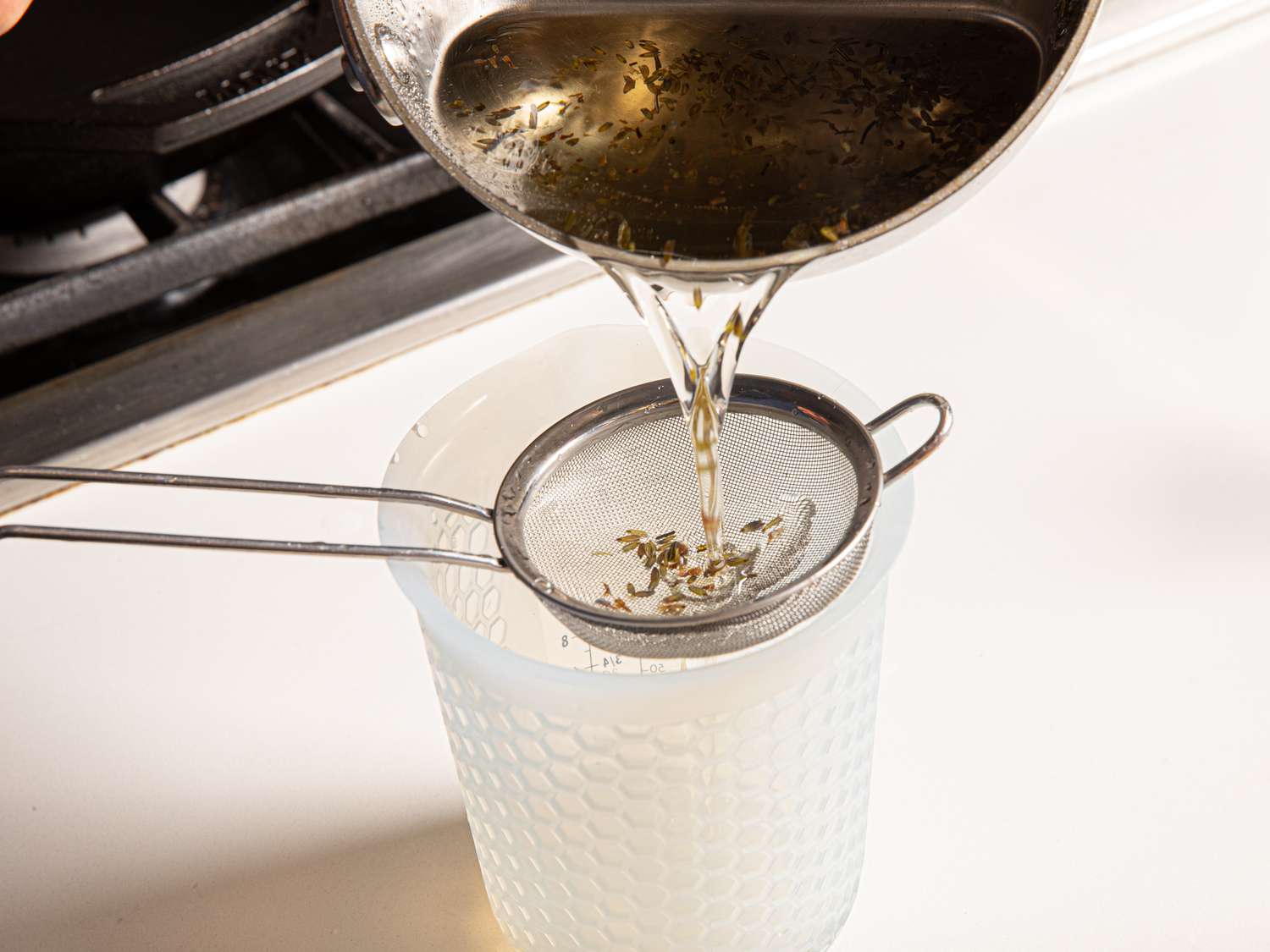 Overhead view of straining lavendar syrup