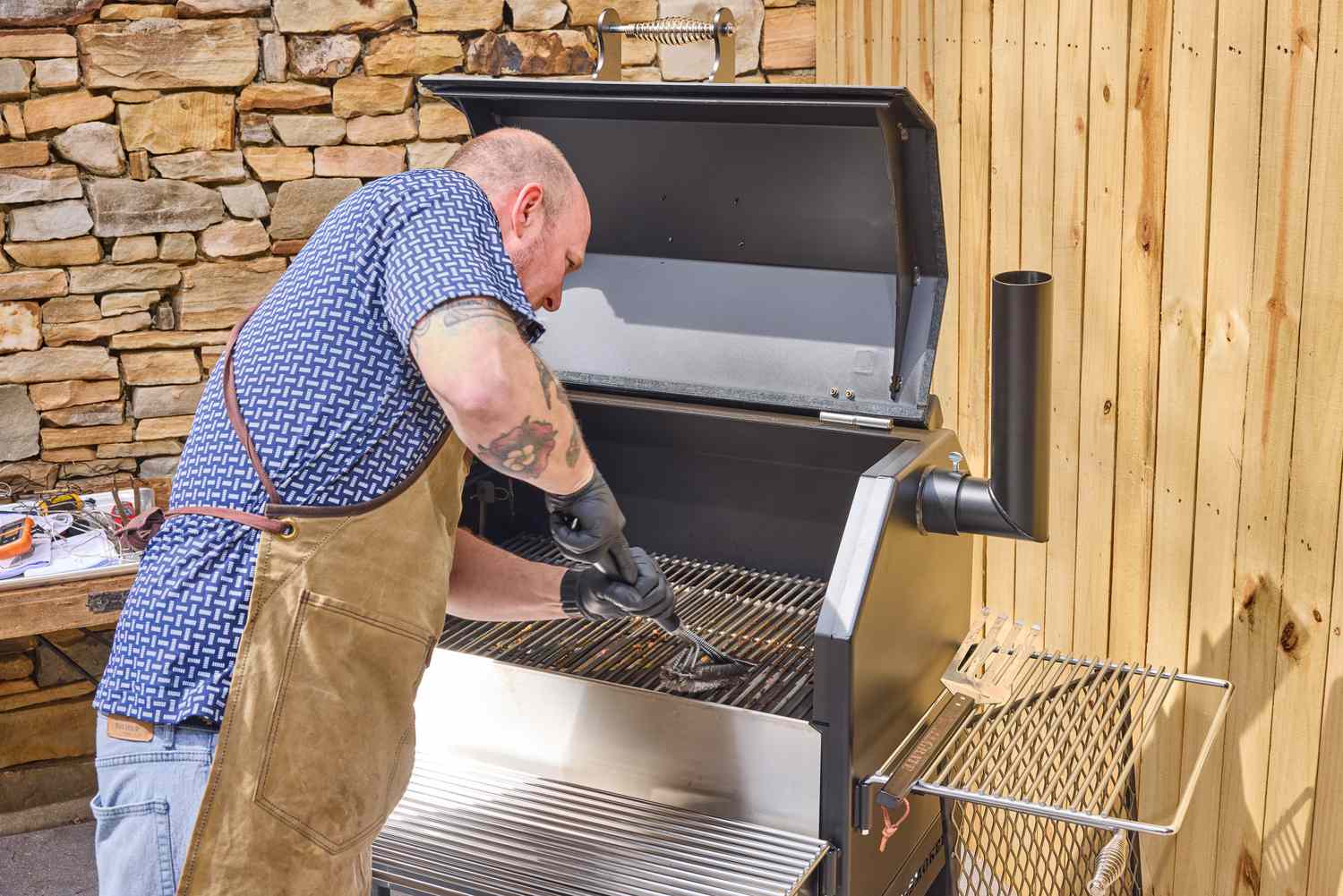 A person cleans the Yoder Smokers YS640S Pellet Grill