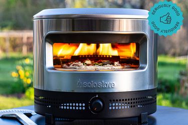 the solo stove pizza oven with a pizza baking inside