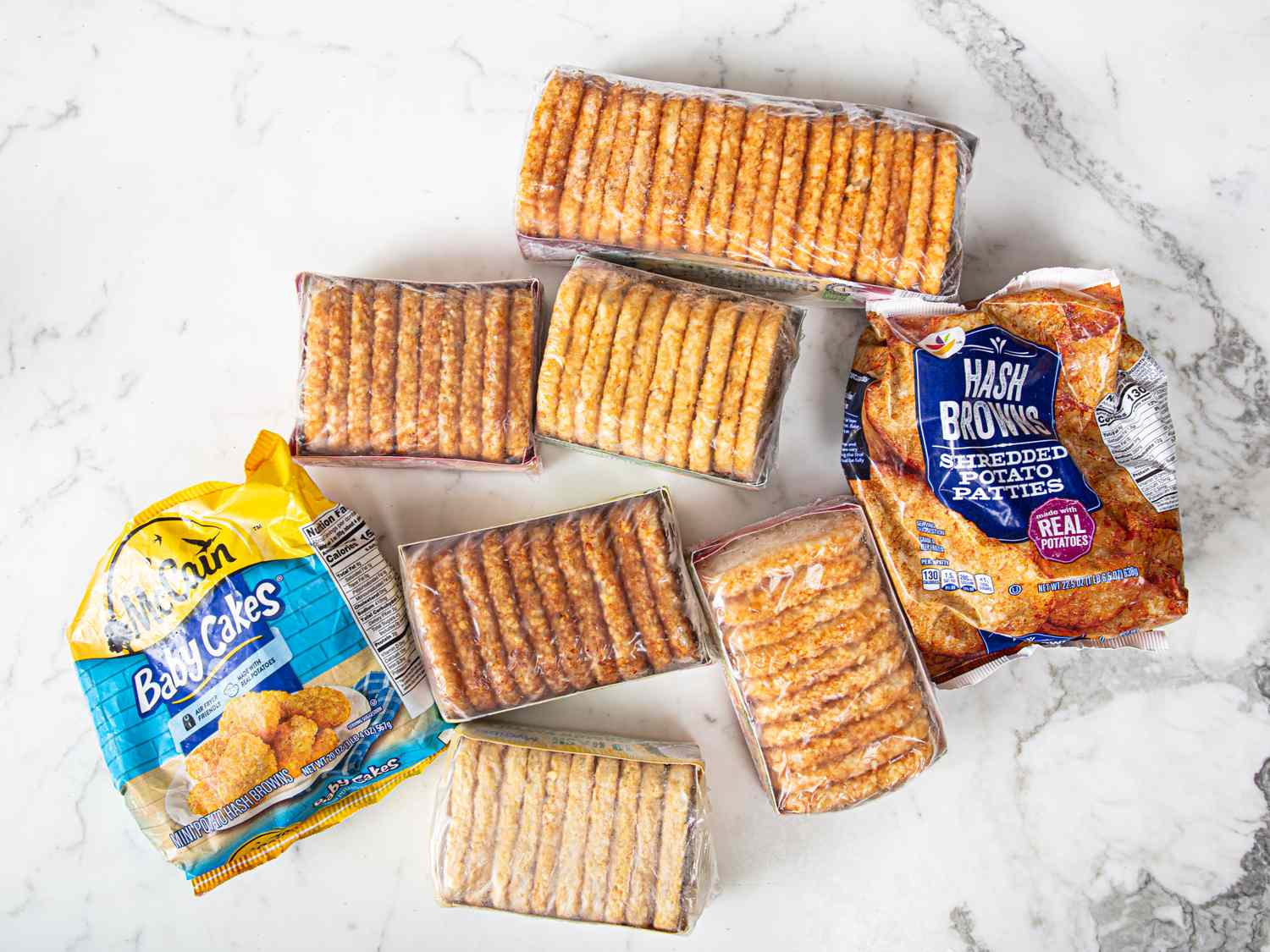 A variety of frozen hash brown products arranged on a marble surface