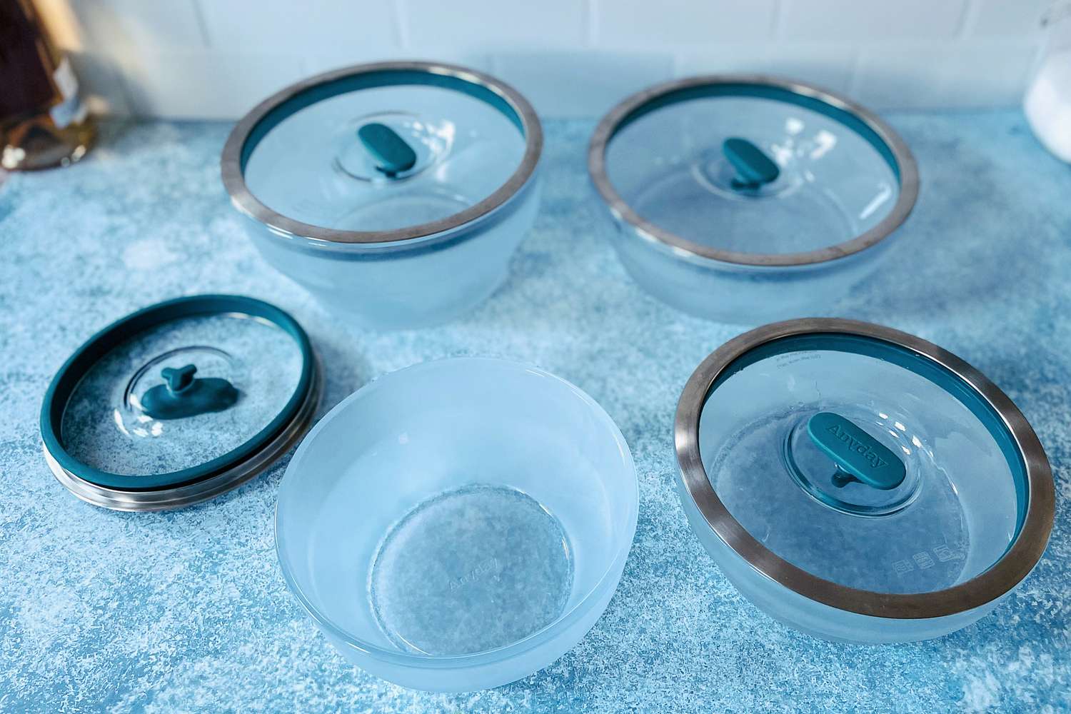 Four Anyday dishes on a blue countertop (one with its lid off)