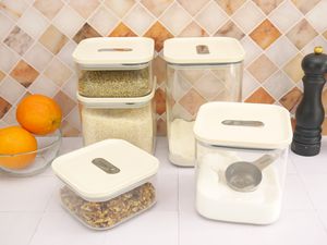 caraway dry food storage containers on a white tile surface