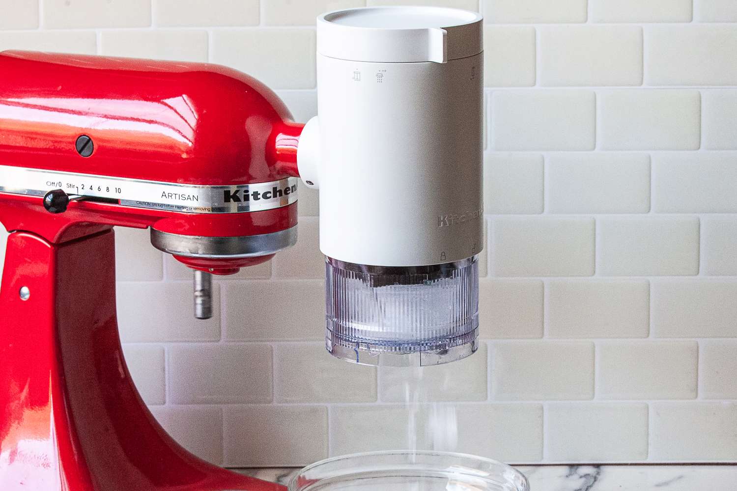 A stand mixer with an attachment for sifting ingredients into a mixing bowl