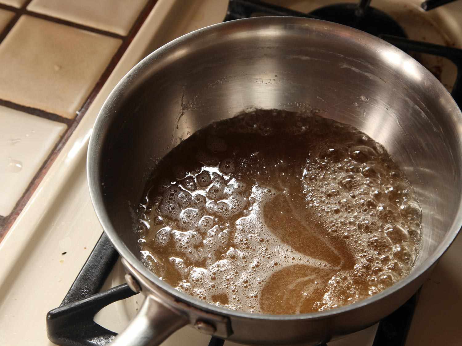 Caramel bubbling in a saucepan on the stove.