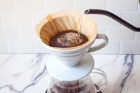 Pour-over coffee brewing in progress with water being poured onto the coffee grounds in the filter