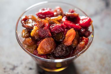 Closeup of a glass overflwoing with tomato raisins.