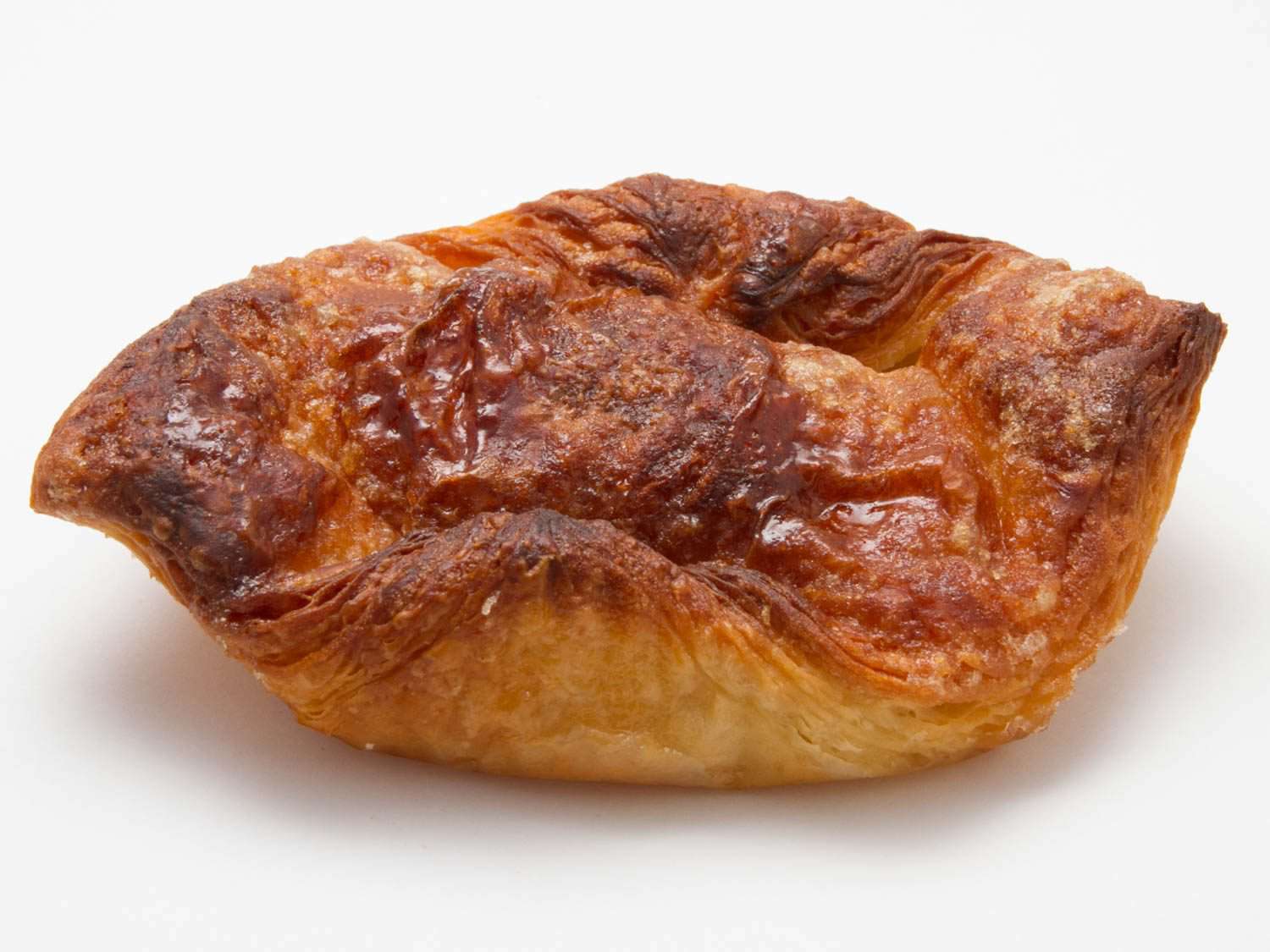 Kouign amann pastry on all-white background.