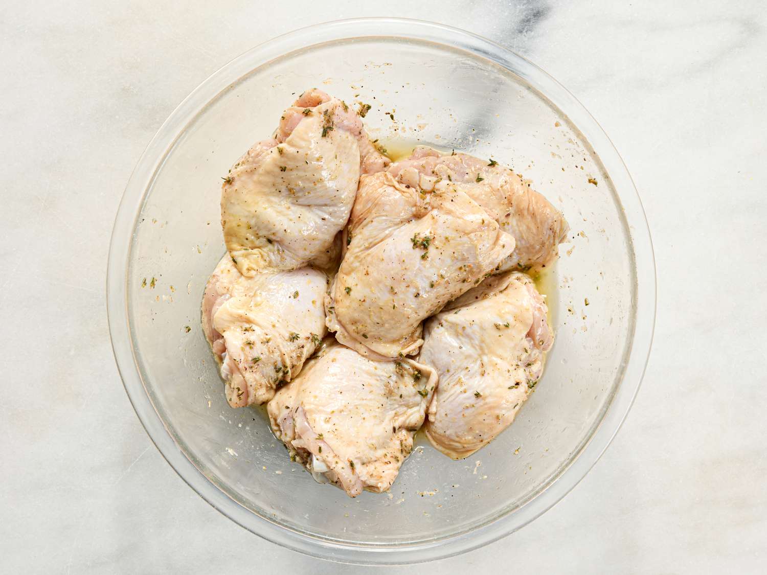Marinated chicken thighs in a glass bowl