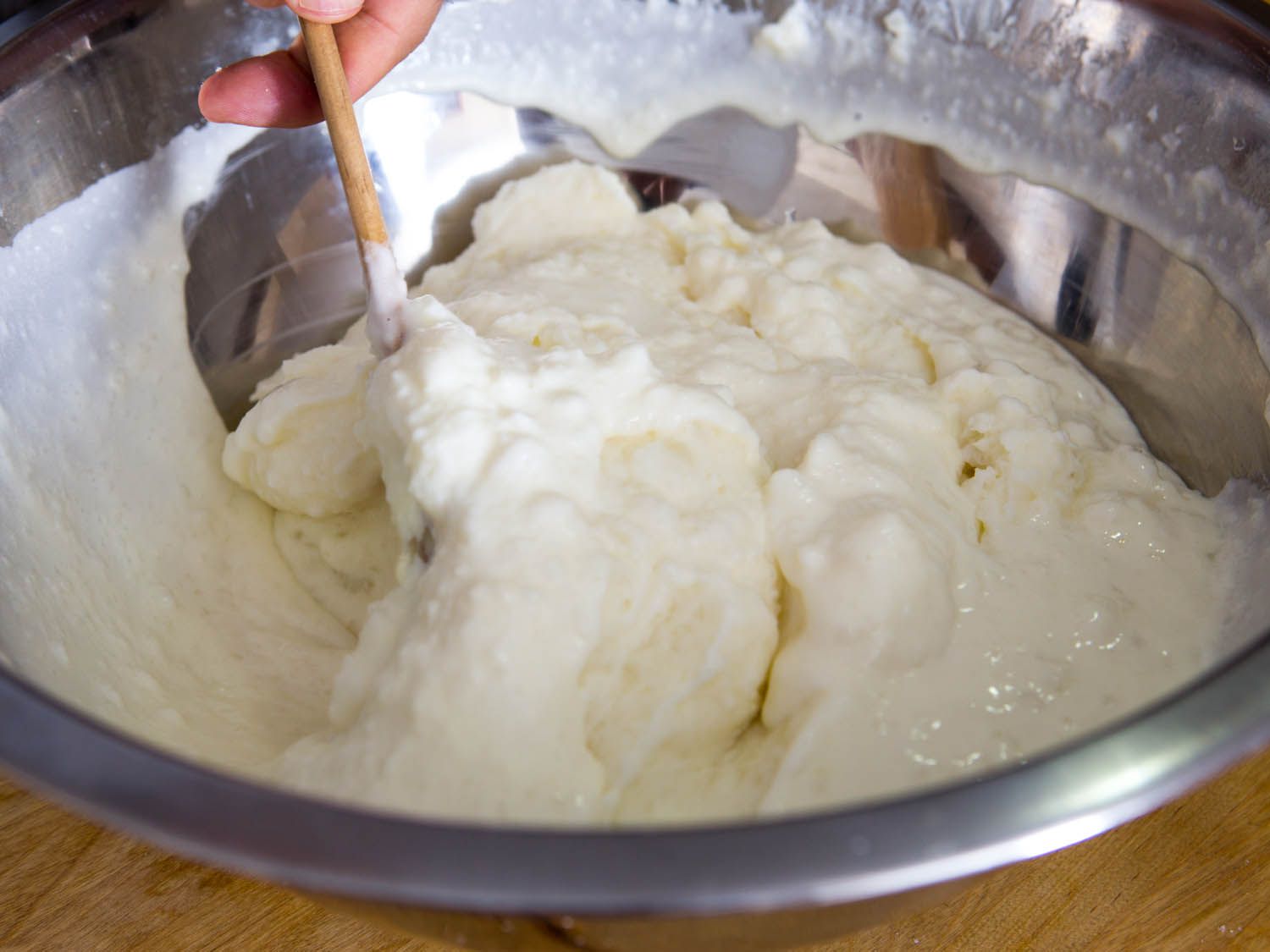 Stirring cream into mashed potatoes.