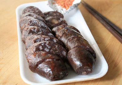 Korean blood sausages sliced on a rectangular white plate. 