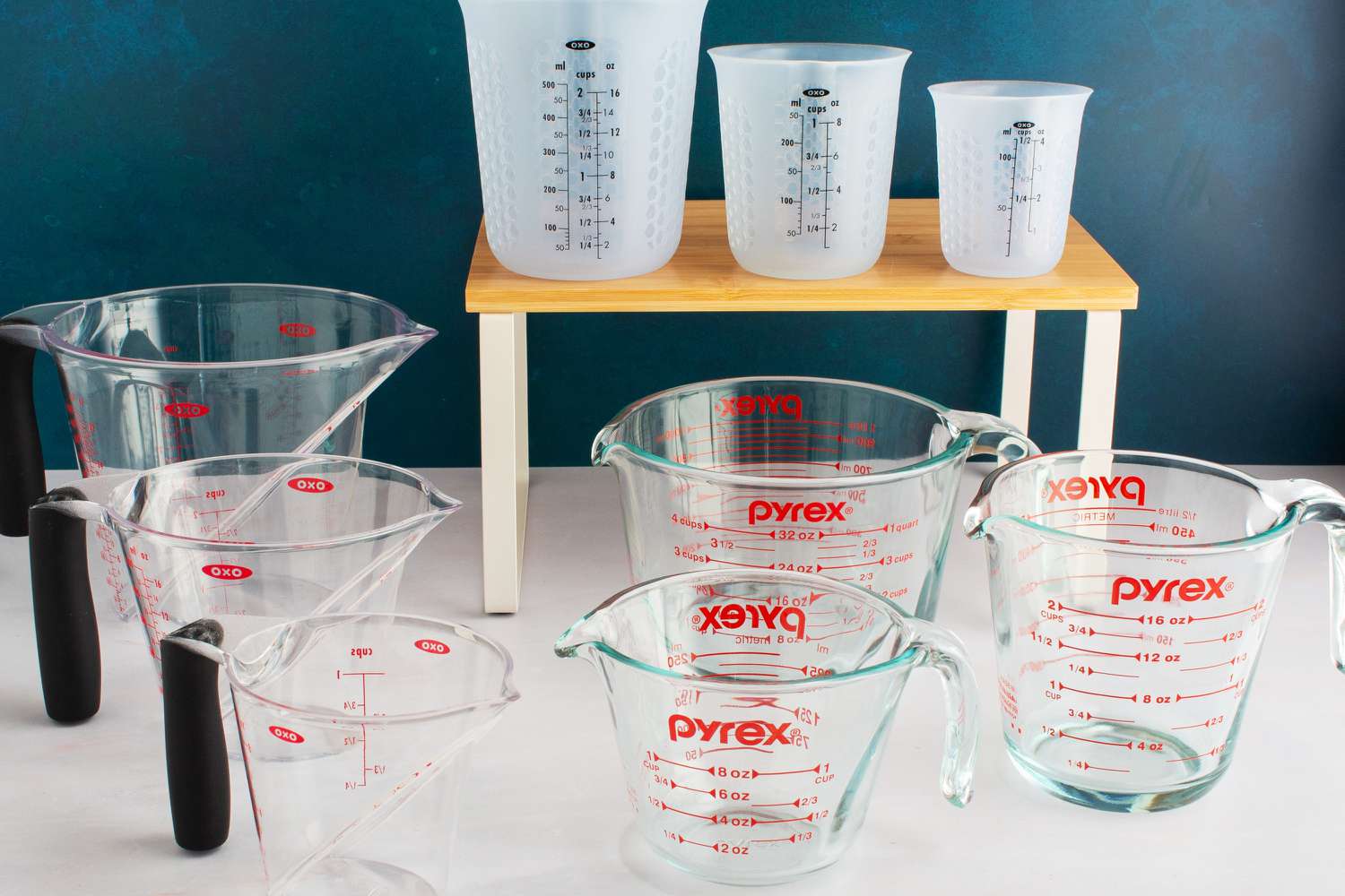Three sets of liquid measuring cups on a kitchen countertop.