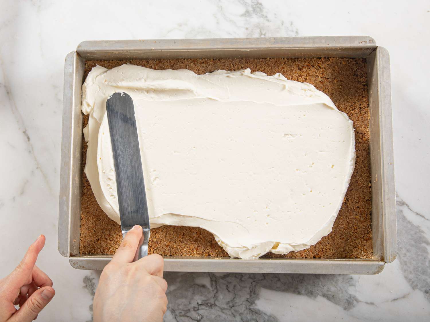 Overhead view of spreading icing on crust