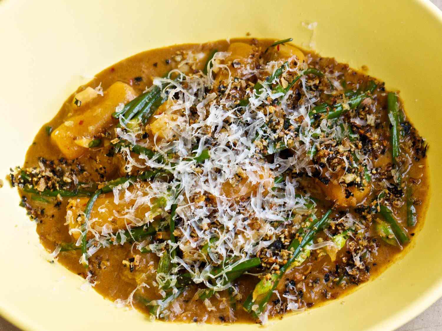 A shallow bowl filled with Korean clam sauce topped with Parmesan.