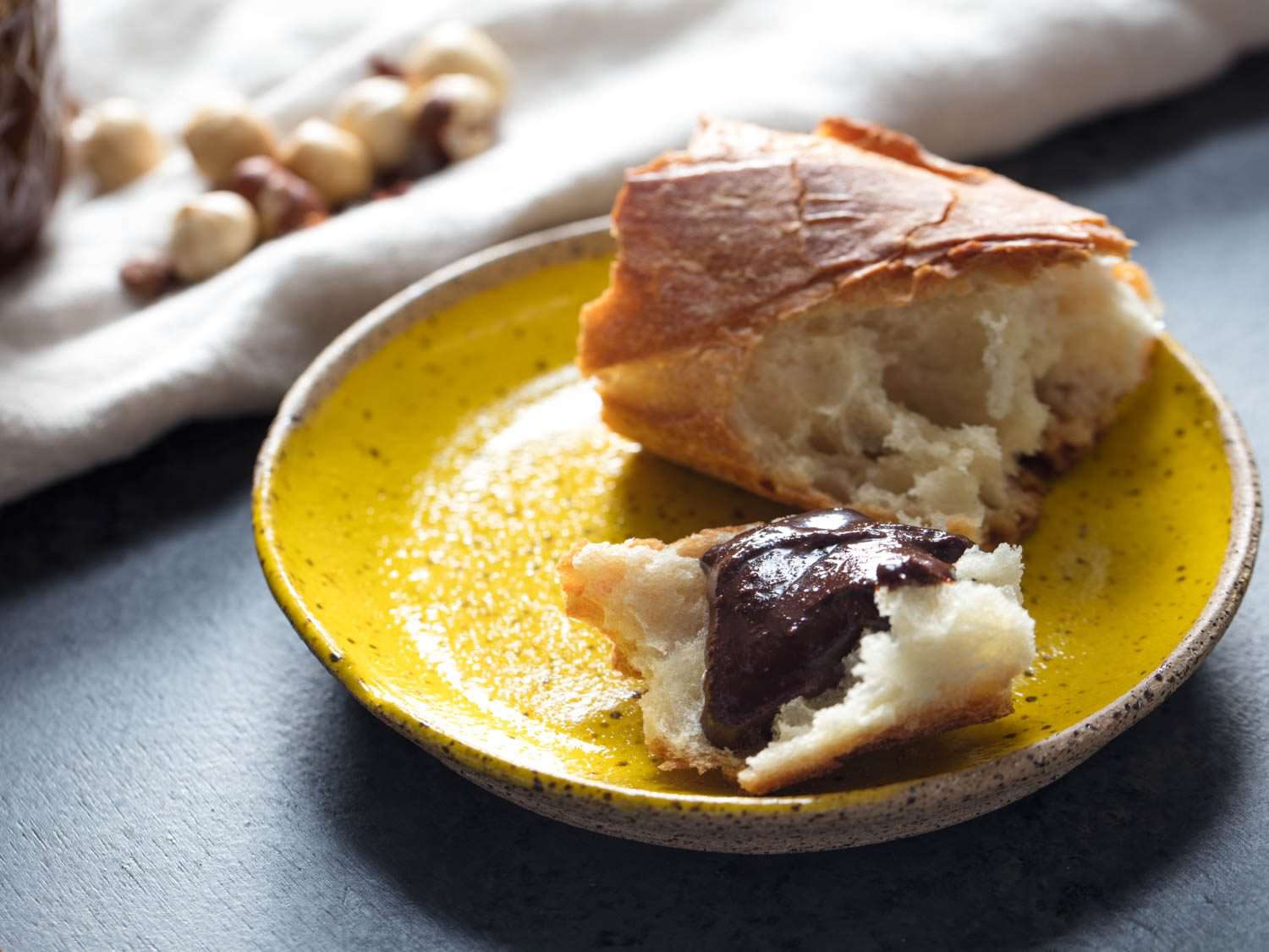 The freshly made chocolate-hazelnut spread is slathered over a torn hunk of baguette.