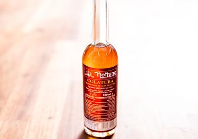 Closeup of a bottle of aged Italian fish sauce called colatura.