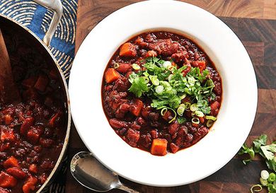 Overhead view of a bowl of vegan sweet potato and 2-bean chili with hominy.