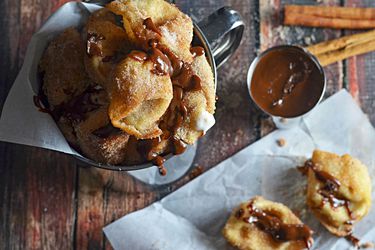Overehad view of Crispy Cinnamon-Sugar-Coated Cream Cheese Wontons, served with a Nutella-Dulce de Leche Dipping Sauce.