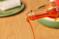 Adoboloco Island Wings Pineapple Cayenne Pepper Sauce being poured