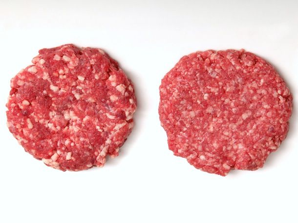 An overhead shot of two raw burger patties. The one on the left is coarsely ground and the one on the right is finely ground.