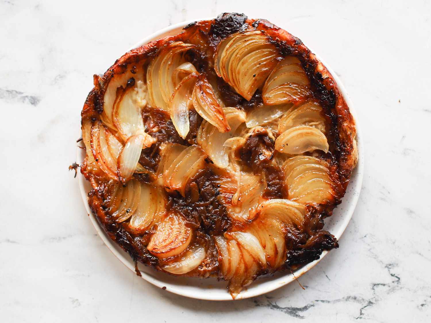 Onion tarte tatin displayed on a marble counter