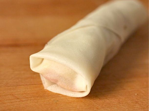 Closeup of a tightly rolled egg roll, ready to fry.