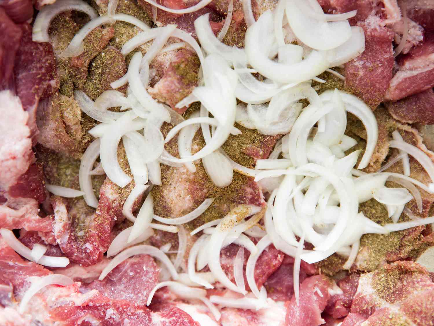 The pork is combined with onions and the marinade ingredients.