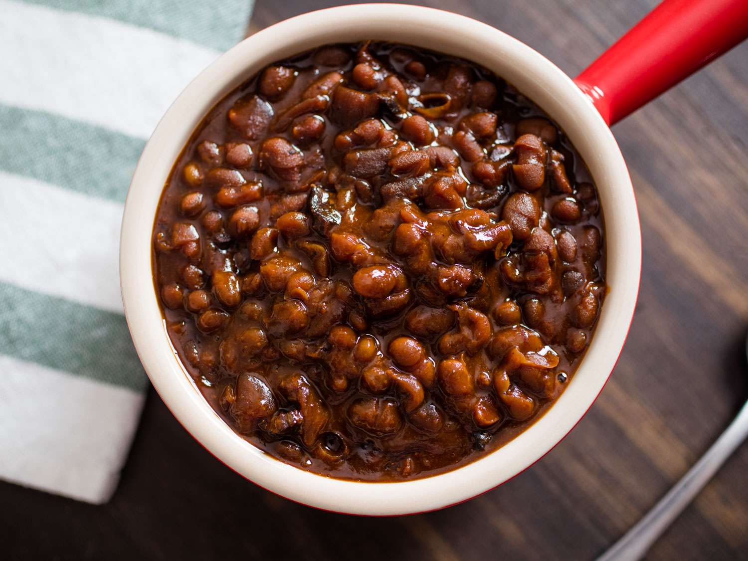 Small red crock filled with slow-cooked Boston baked beans.