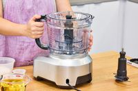A person attaches the bowl to the Breville 16-Cup Sous Chef Peel & Dice Food Processor