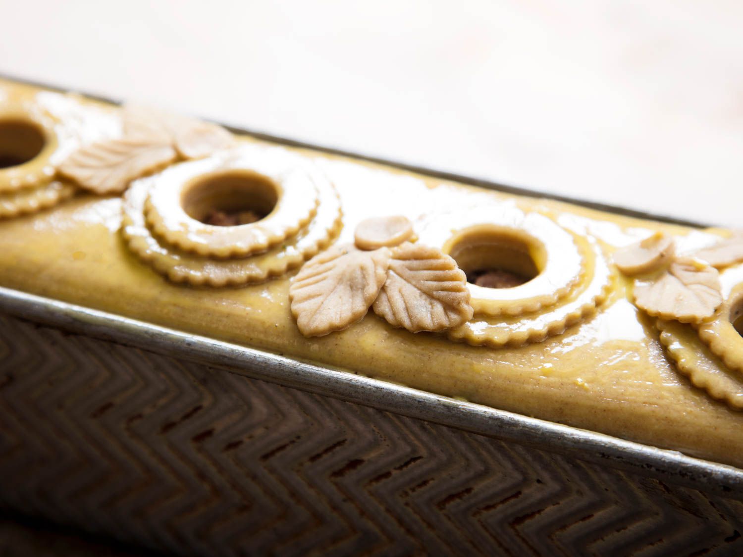 Closeup of the découpage and chimneys of an unbaked pâté en croûte.