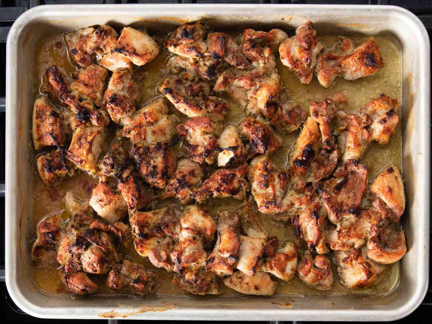 cooked pieces of chicken on a quarter sheet tray