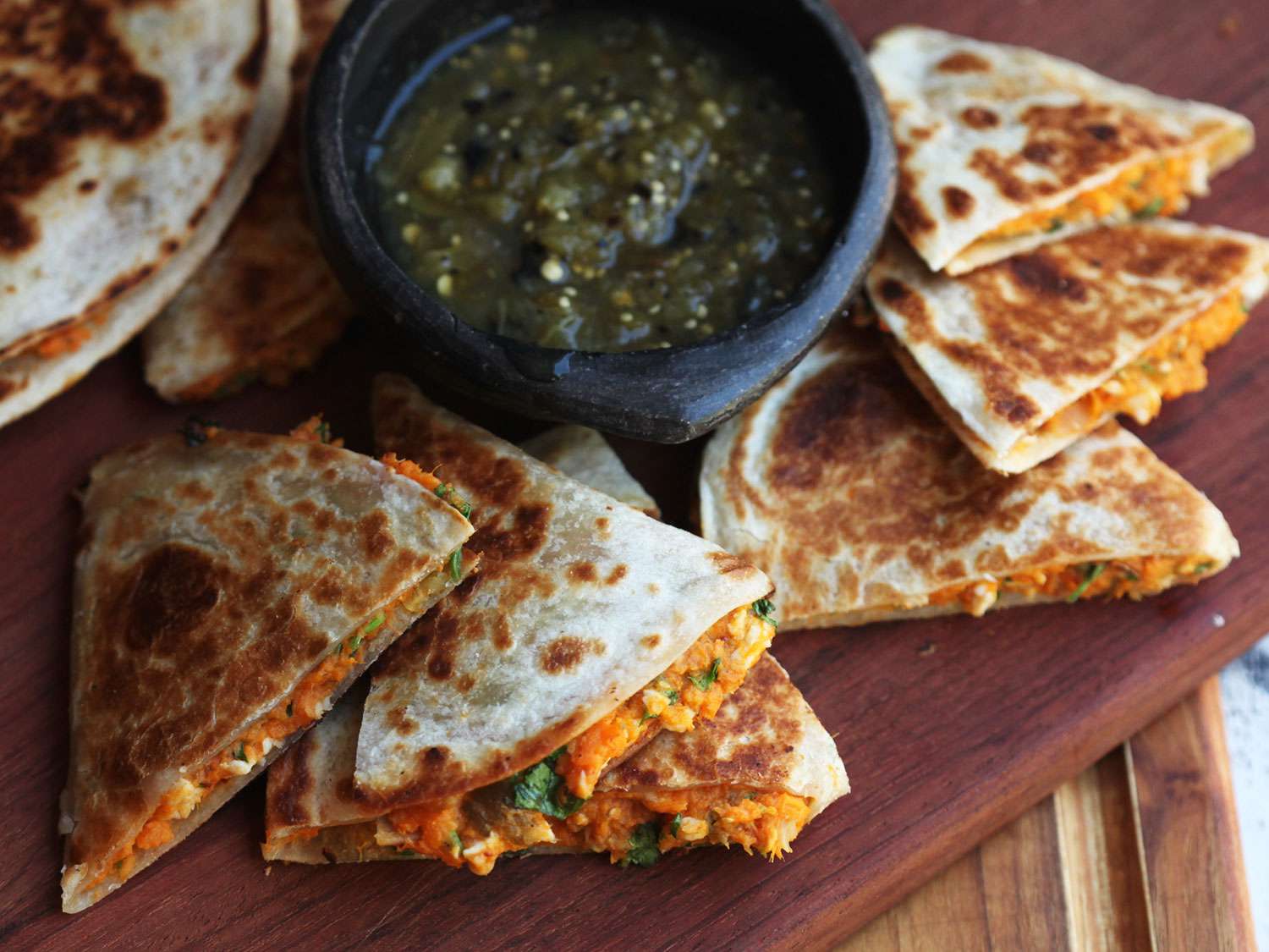 Sweet potato quesadilla cut into wedges and served with salsa verde. 