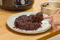 A person cuts a cake baked in the Instant Pot Pro 10-in-1 6-Quart Pressure Cooker