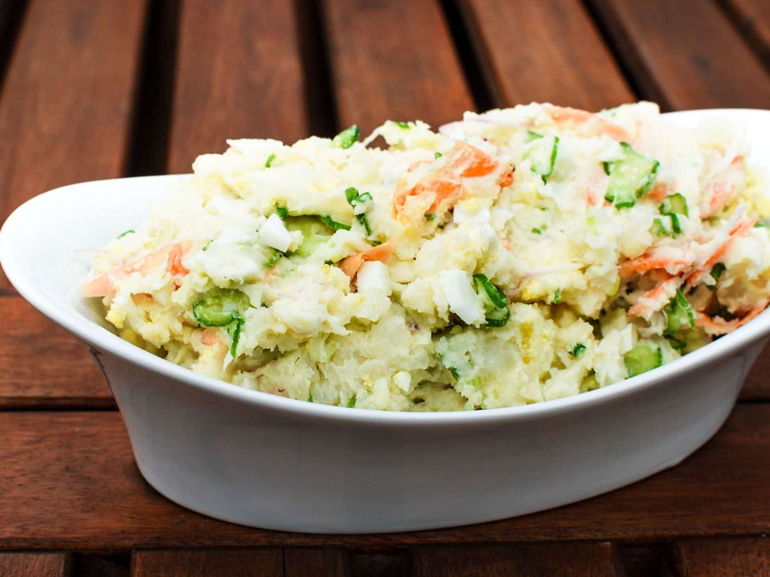 A white dish of Japanese Potato Salad With Cucumbers, Carrots, and Red Onion